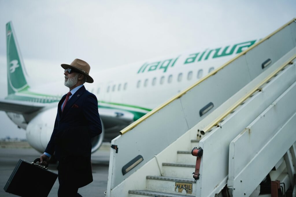 pexels-photo-30692470-30692470 A stylish businessman with a briefcase exits a plane marked Iraqi Airways.